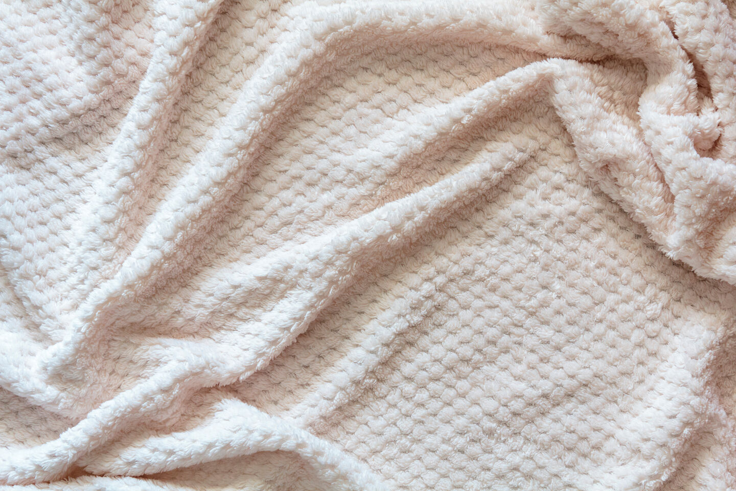 A wool blanket with gentle wrinkles, showcasing its soft texture and cozy appearance, ideal for a warm and inviting setting. A wool blanket with gentle wrinkles, showcasing its soft texture and cozy appearance, ideal for a warm and inviting setting.